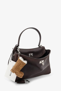 Balenciaga women’s rodeo dark brown leather crossbody bag with silver hardware and plush tan boot charm hanging from handle
