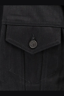 Close up of balenciaga women’s standing black denim jacket pocket with circular metal button engraved with brand text