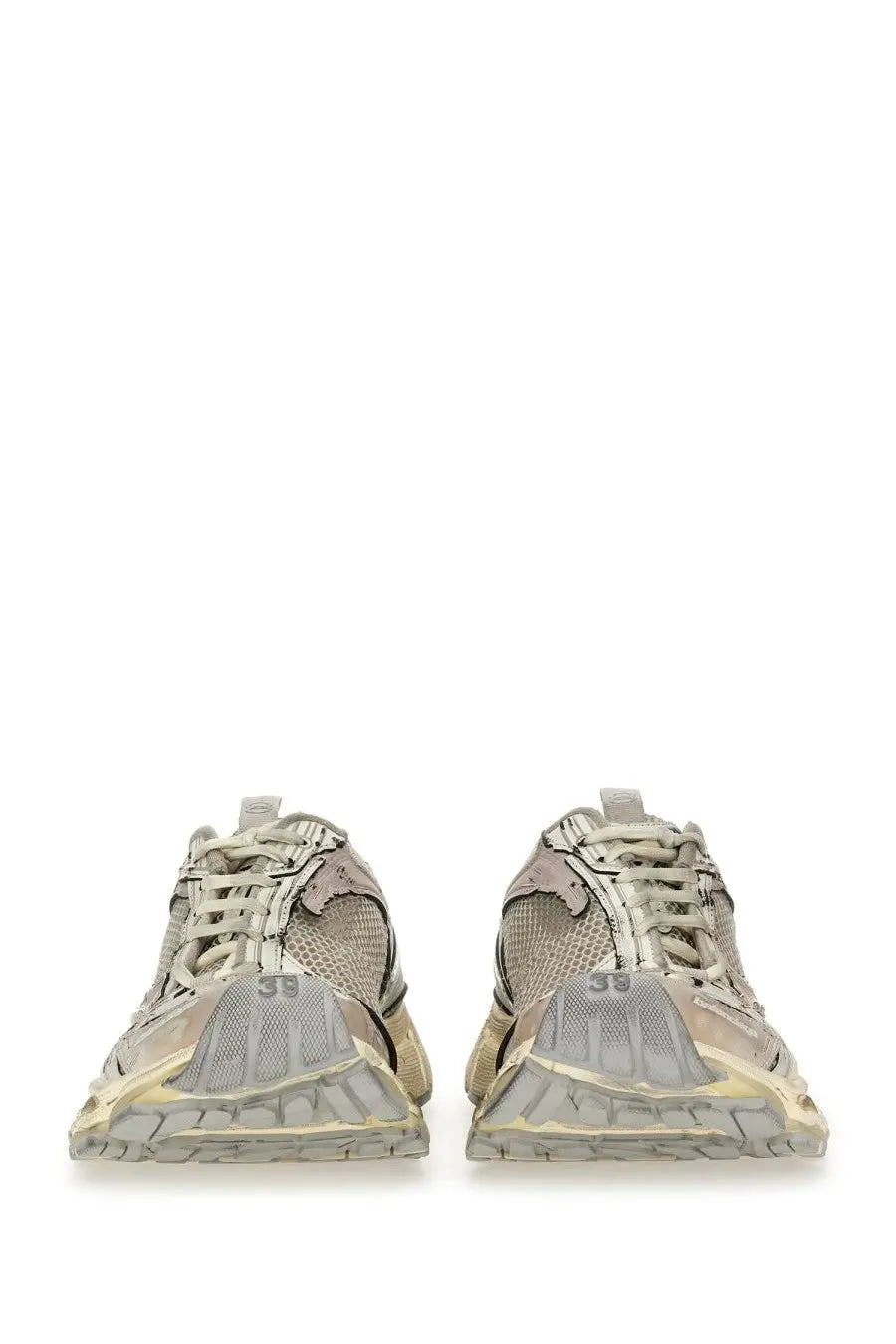 A pair of distressed beige and gray balenciaga women’s stapler sneakers with chunky soles