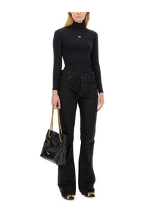 Black textured Balenciaga tote bag with gold chain strap paired with women’s straight black pants