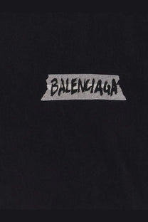 Black balenciaga women’s cotton t shirt with used effect featuring a graffiti style logo on torn tape graphic