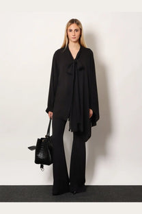 Balenciaga women’s black satin blouse with draped bow neckline paired with viscose trousers in black