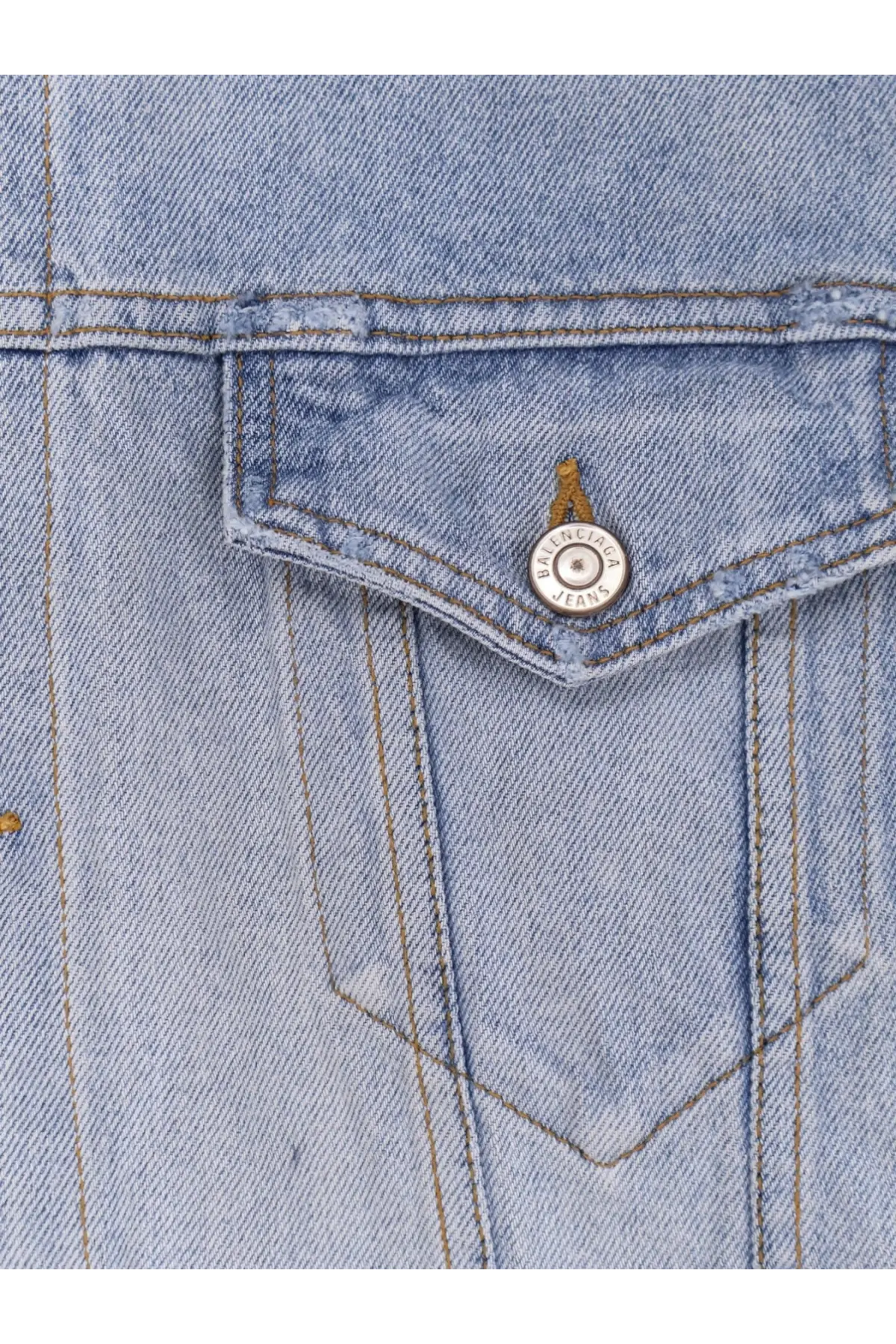Light-wash denim jacket pocket with a silver Balenciaga jeans button on a Balenciaga women’s washed out denim jacket blue
