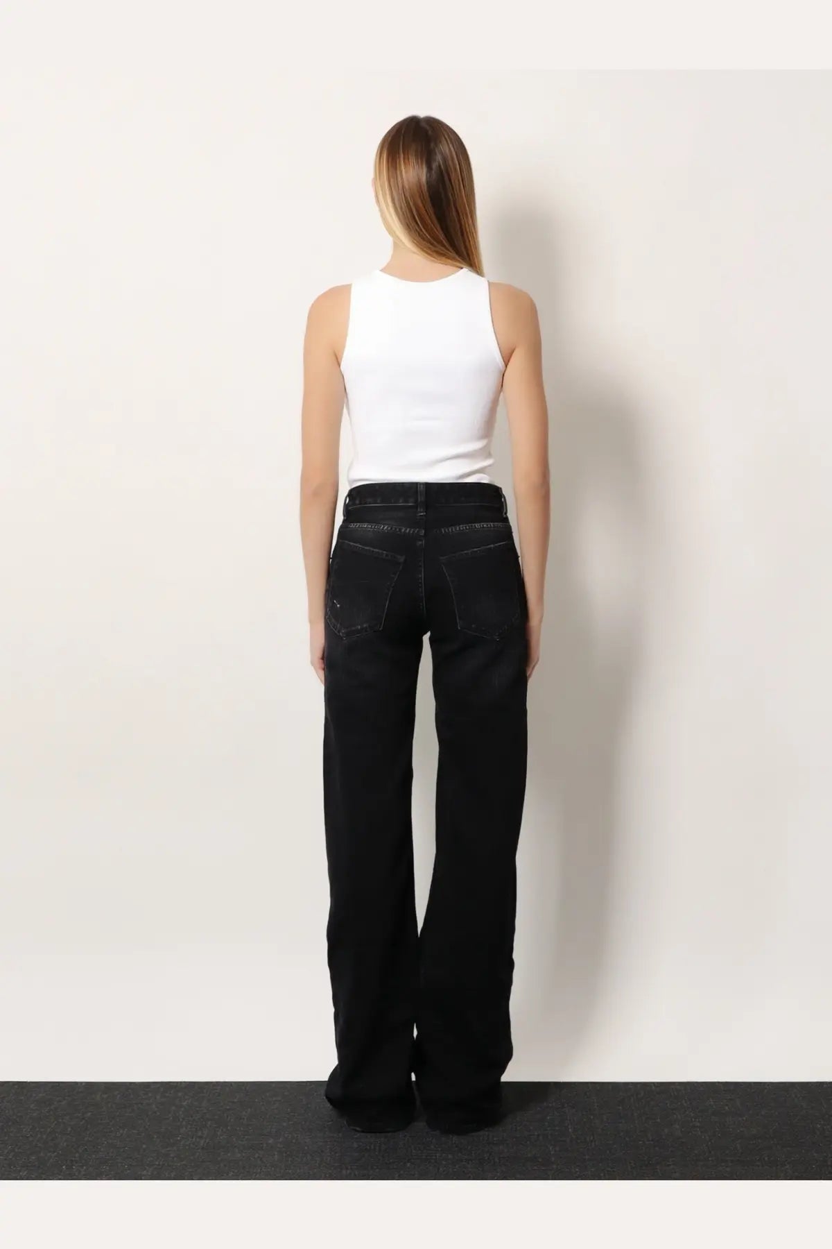 Balenciaga women’s wide leg black denim trousers showing back side with straight-cut silhouette and classic pockets