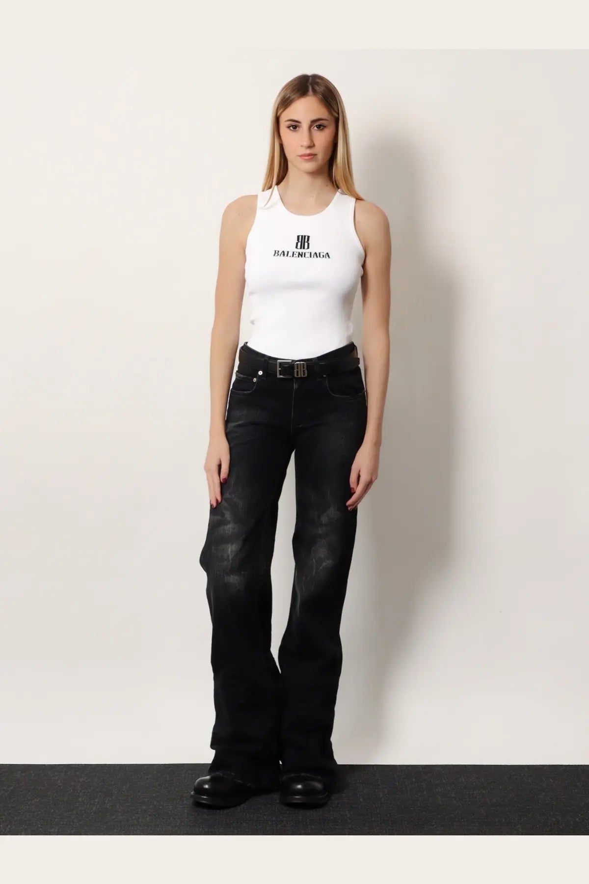 White balenciaga tank top with black logo and lettering paired with women’s wide leg black denim trousers black
