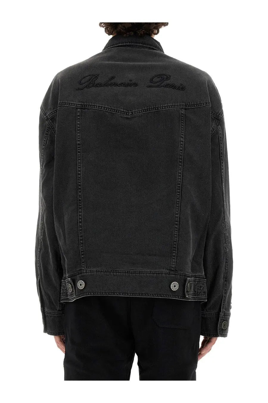 Balmain men’s black denim jacket showing the back with balmain paris embroidered in dark thread
