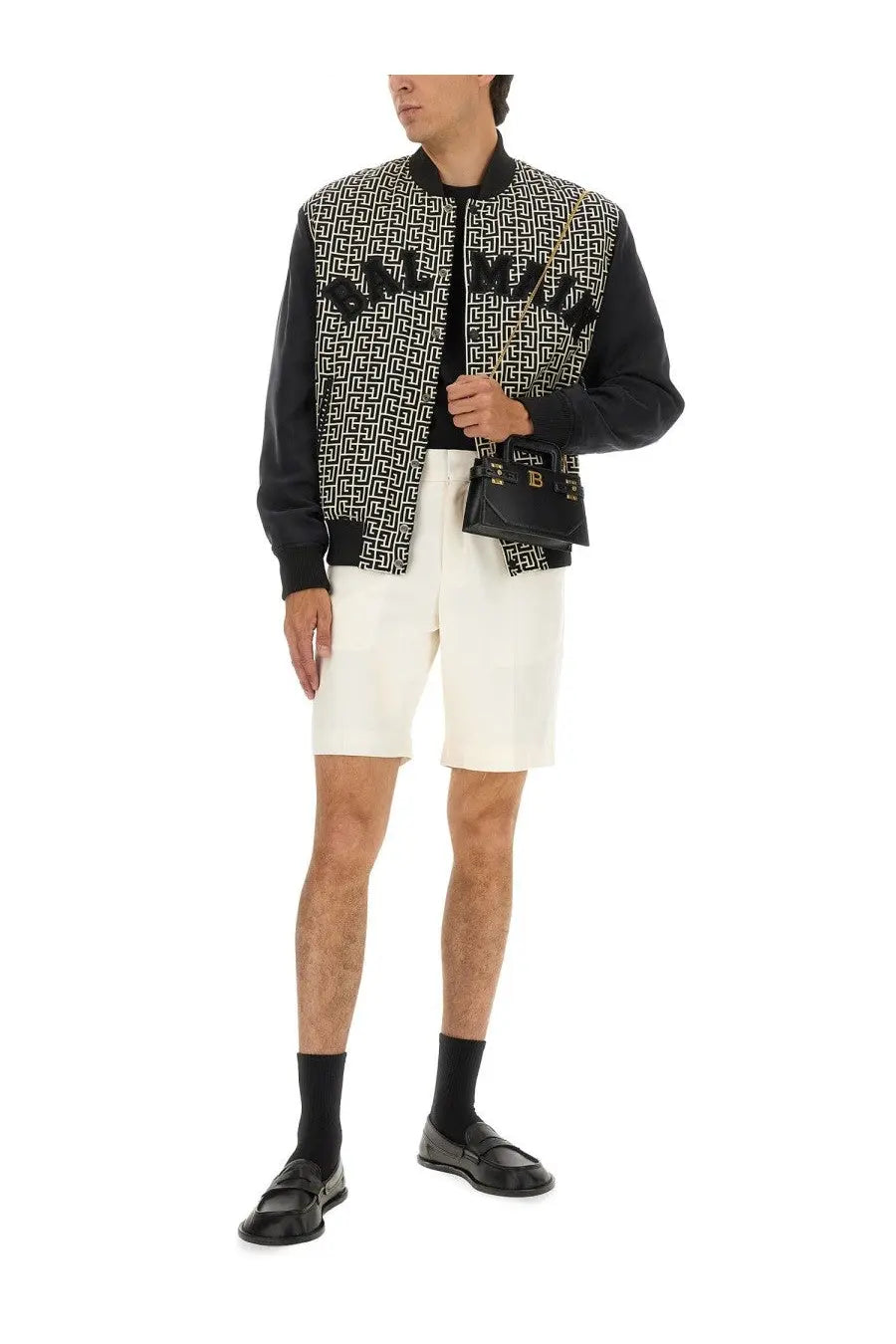 Black givenchy bag with gold-tone hardware and repeating monogram pattern complementing balmain mens varsity jacket