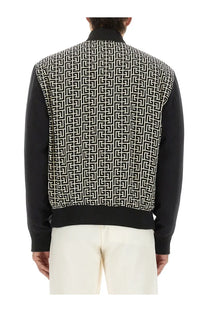 Balmain men’s black and white patterned bomber jacket with repeating geometric monogram logo design multicolor