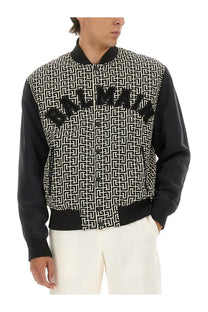 Balmain men’s multicolor black and white patterned monogrammed varsity bomber jacket with bold Balmain lettering across chest