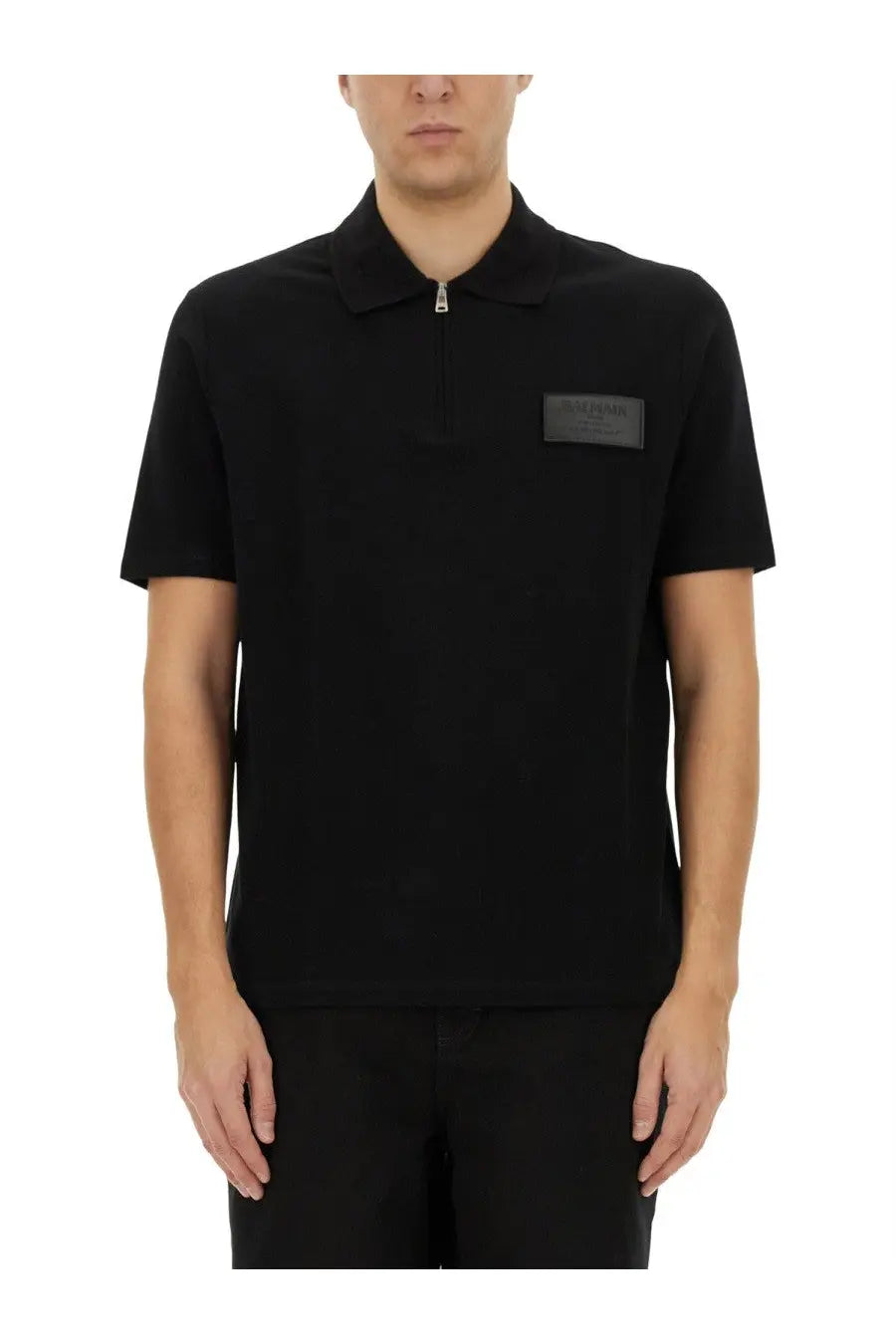 Balmain men’s black short-sleeved polo shirt with half-zip collar and dark gray brand patch on left chest
