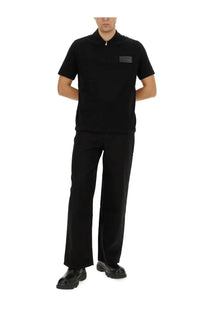 Balmain men’s black short-sleeved polo shirt with subtle collar zipper and rectangular chest patch in cotton blend