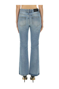 Back side view of balmain women’s blue light-wash denim flare jeans with classic pockets and black waistband label
