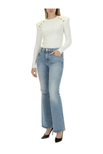 White long-sleeved top with gold button embellishments on shoulders paired with balmain women’s blue flare fit jeans