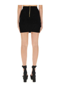 Back view of balmain women’s black knit ribbed mini skirt with gold zipper detailing
