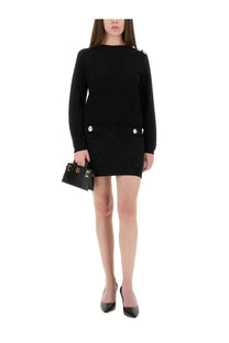 Black balenciaga mini handbag with gold-tone hardware and structured design paired with balmain womens black knitted top
