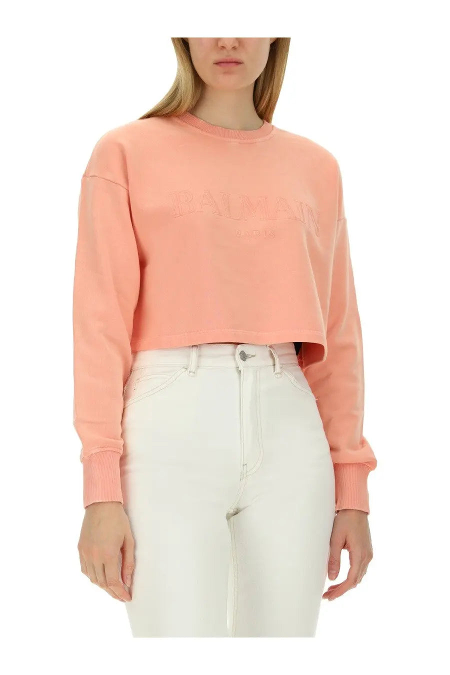 Balmain women’s soft peach-colored cropped long-sleeve sweatshirt with subtle embroidered logo across the chest