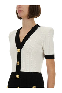 Balmain women’s two tone bodycon dress multicolor paired with a chic white and black cable-knit cardigan with gold medusa buttons