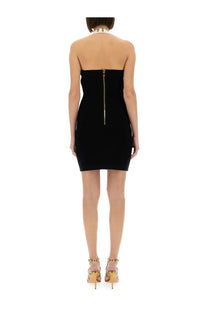Balmain women’s two tone black strapless mini dress with gold zipper back and matching gold studded heels shown from back