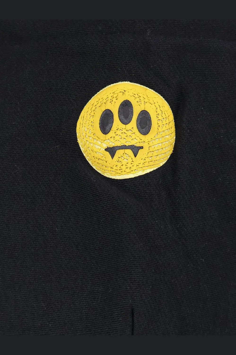 Barrow men’s black cotton sweatshirt featuring a bright yellow textured circular smiley face patch with three eyes and fangs