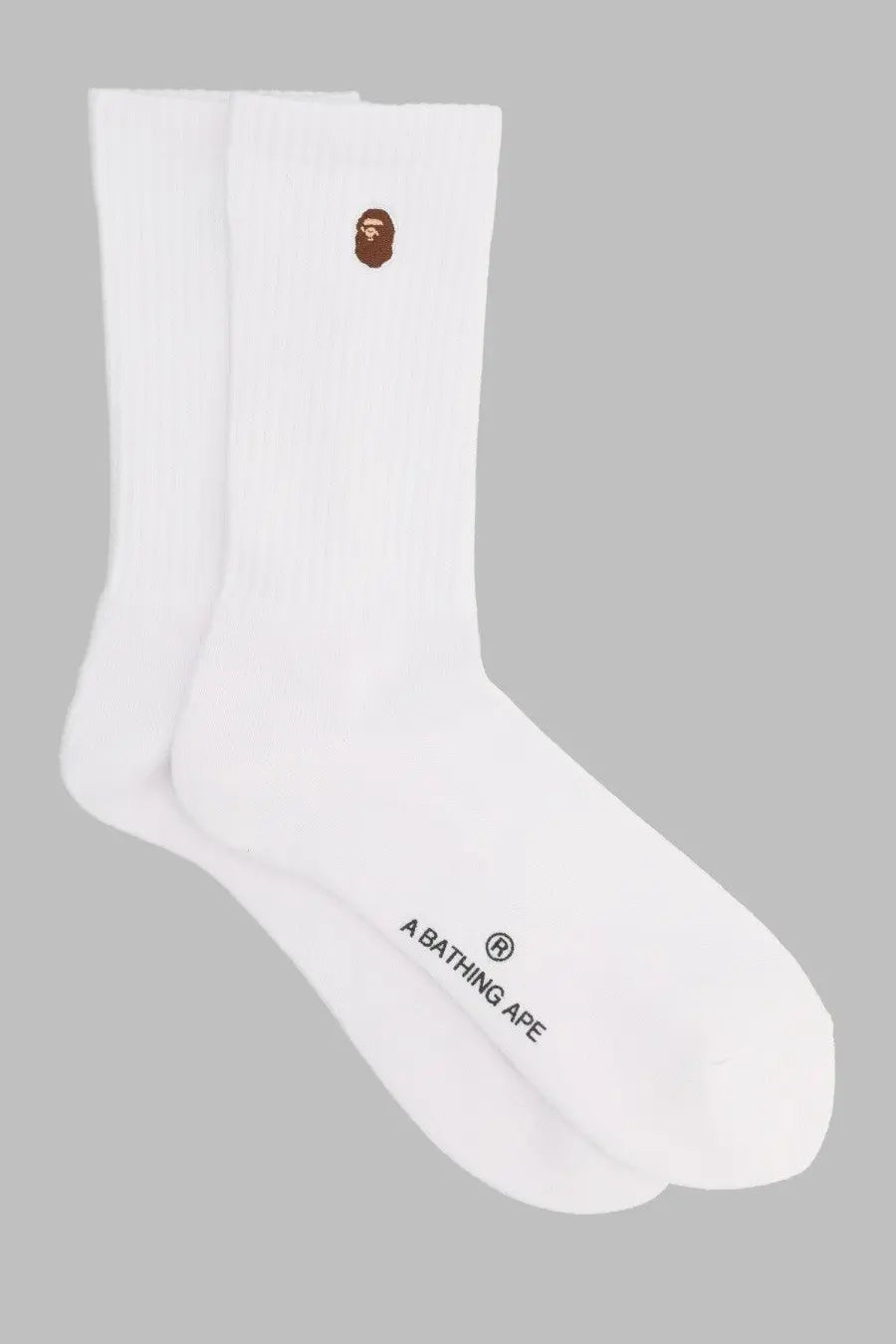 A bathing ape men’s white crew socks with brown embroidered ape face logo on cuff and black branding near heel
