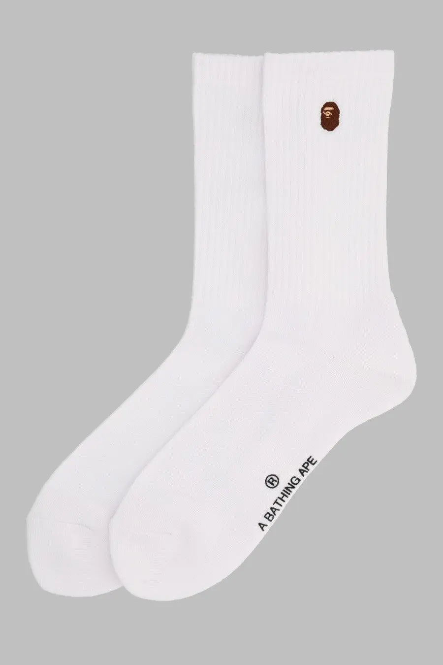 White crew socks with brown a bathing ape logo embroidered on cuff and brand text printed on heel back side view