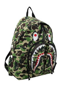A bathing ape men’s green and brown camouflage backpack with a black white and red shark face design