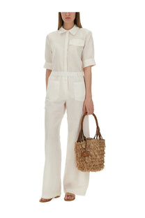 A woven straw tote bag with fringed detailing and brown leather handles paired with baum und pferdgarten women’s shirt majken white