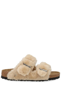 Beige birkenstock women’s arizona slide sandals with shearling-lined fluffy straps and silver buckle accents
