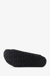 Black rubber sole with a distinctive wavy textured pattern on birkenstock women’s arizona rivet suede sandals black