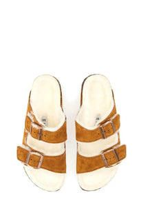 Birkenstock women’s arizona sandal in tan suede with three adjustable straps and plush white shearling lining