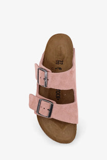 Birkenstock women’s arizona suede sandal in pink with two silver buckle straps and brown cork footbed