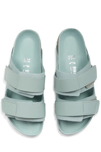 Birkenstock women’s uji sandal green with light blue suede-like straps and cork footbed featuring birkenstock logo