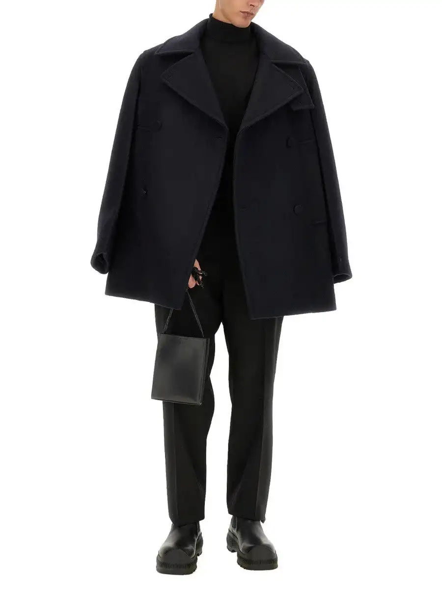 Black woolen double-breasted coat with wide lapels and a structured silhouette.