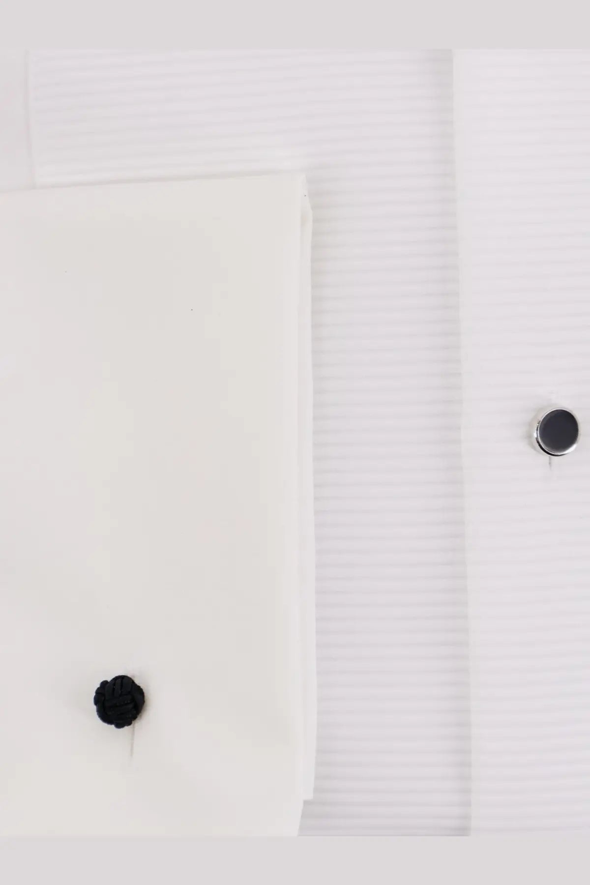 Black knitted cufflink on a white boss men’s cotton dress shirt cuff for formal wear
