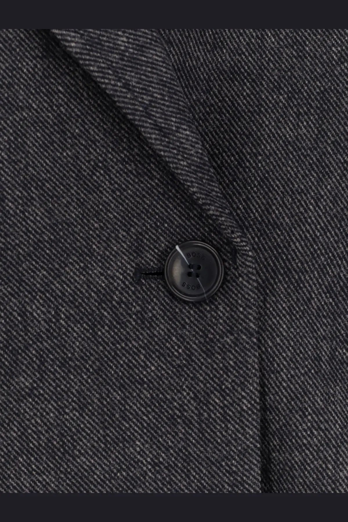 Black button with subtle sheen on textured herringbone wool blend dark gray blazer from BOSS women’s jafleni line