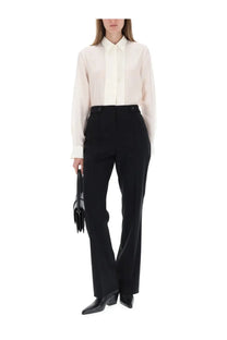 A sleek black leather handbag with structured design and tassel detailing featured with BOSS women’s white shirt