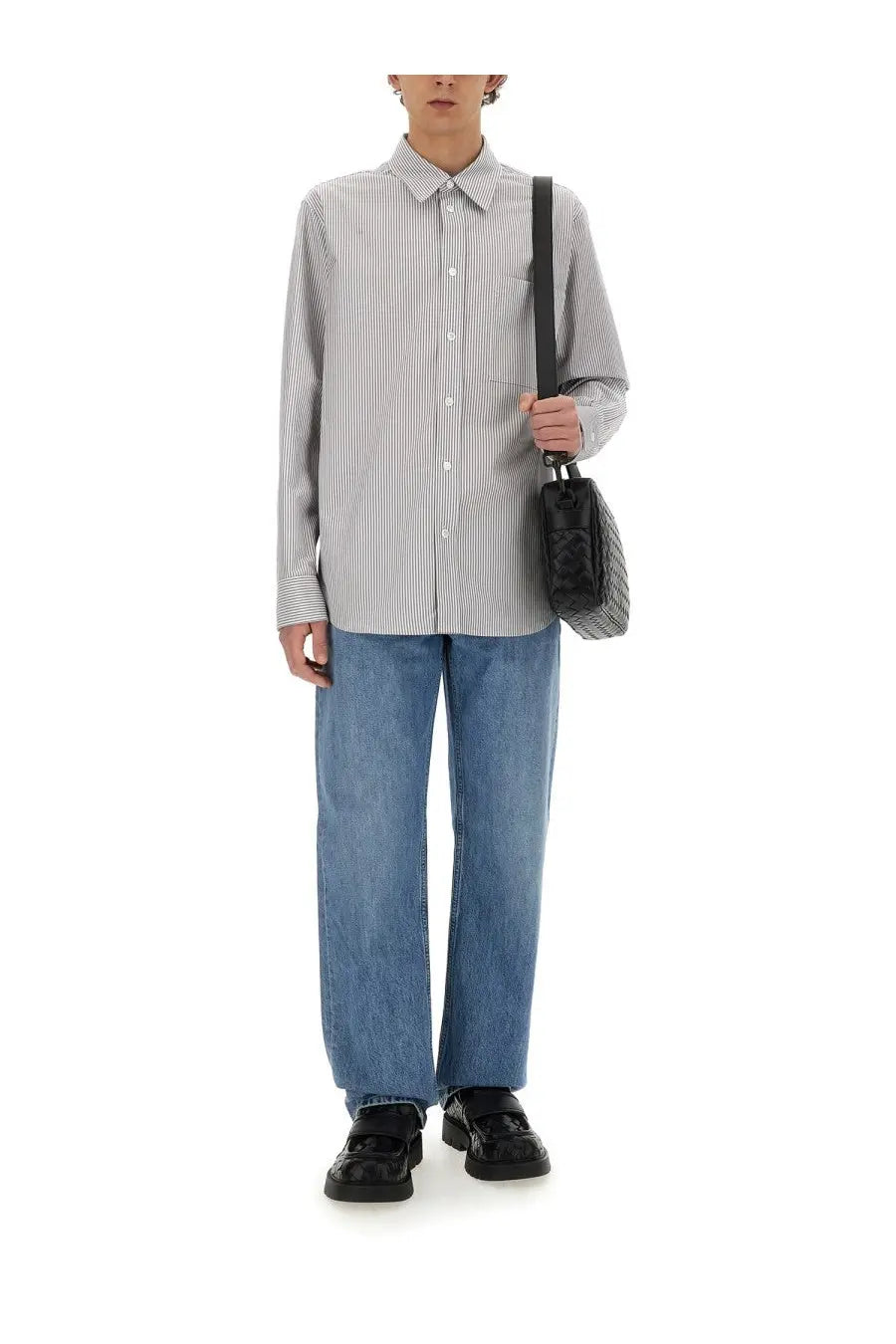 A black quilted shoulder bag with a structured rectangular shape and single strap shown with bottega veneta mens grey cotton shirt
