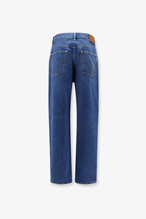 Blue denim straight-leg jeans with medium indigo wash and brown leather patch at waistband by Bottega Veneta