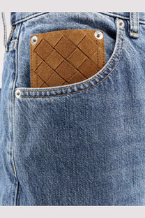 Brown woven leather patch with silver studs and diamond pattern on back of bottega veneta men’s wide leg blue jeans