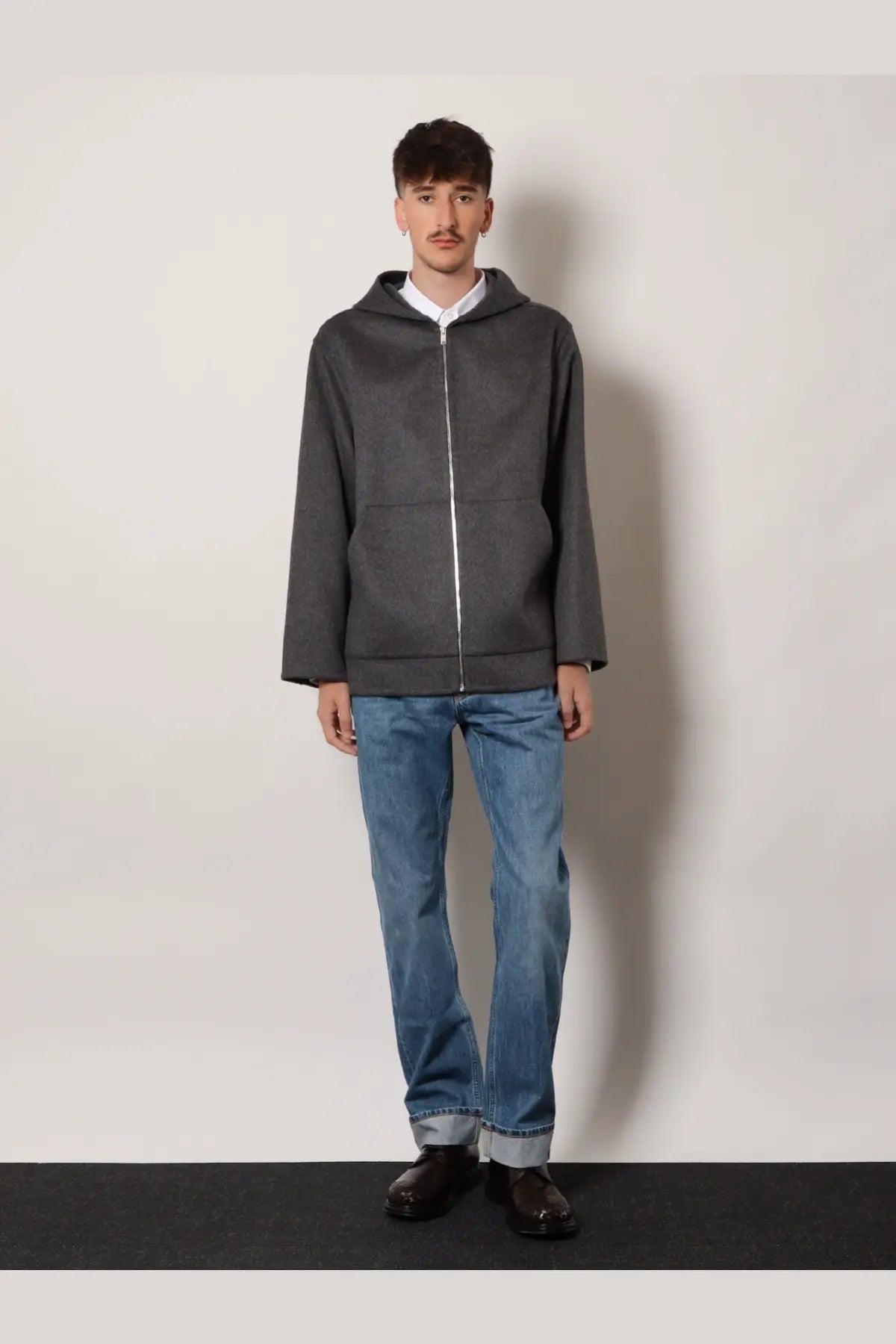 Dark gray zip-up hoodie with subtle texture and contrasting silver zipper paired with bottega veneta men’s wide leg jeans blue