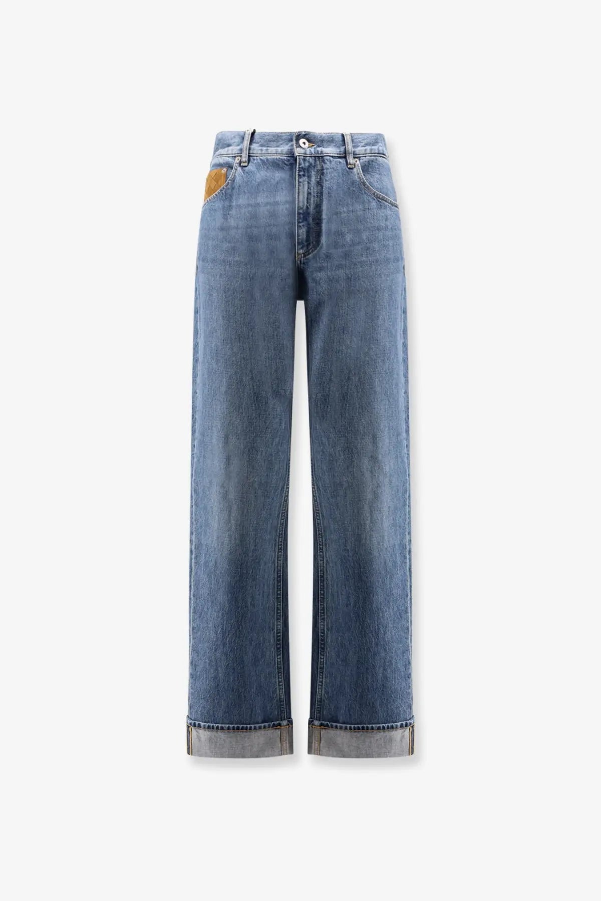 Back side of bottega veneta men’s wide leg blue denim jeans with faded wash rolled cuffs and brown leather patch
