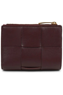Bottega Veneta women’s bi fold wallet in burgundy woven leather with gold tone zipper pull front view