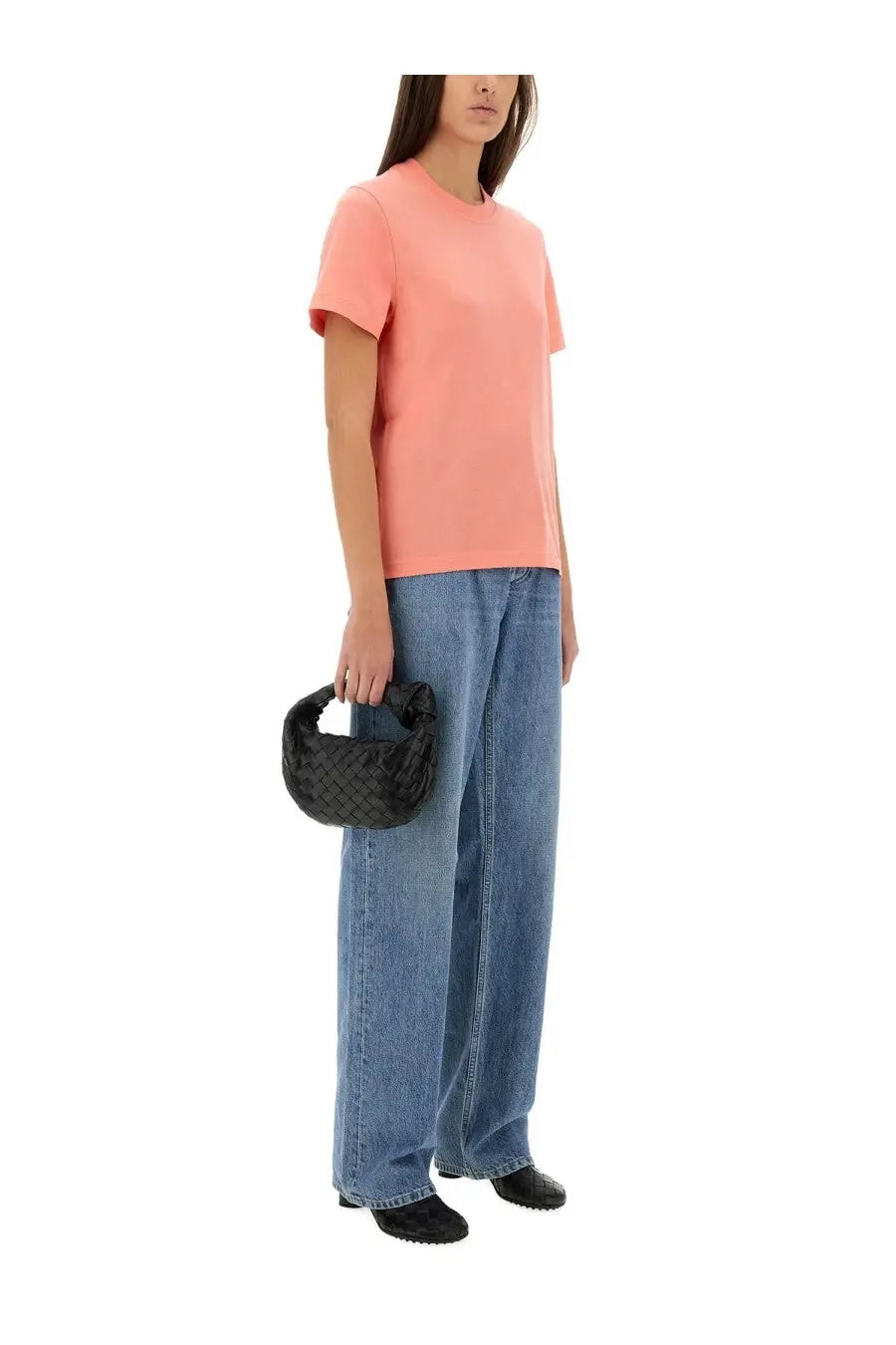 Black woven leather handbag with distinctive knot handle shown alongside bottega veneta women’s blue jersey shirt
