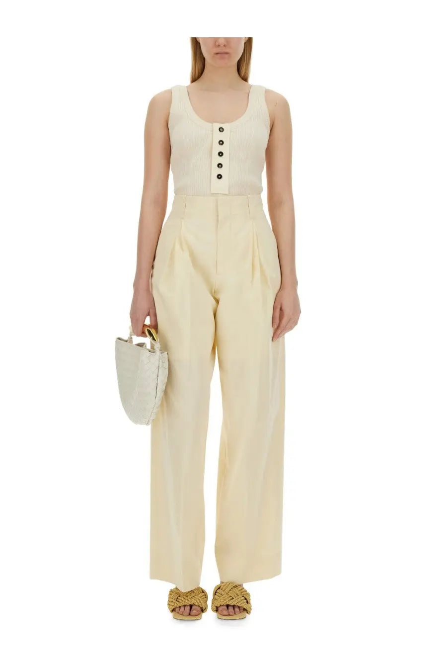 Cream-colored woven handbag with gold-tone handles paired with Bottega Veneta women’s white jersey top