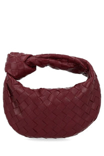 A deep burgundy leather bottega veneta women’s mini jodie bag with a woven knot intrecciato design