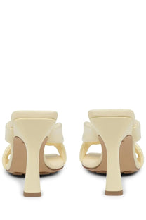 Creamy beige leather mules by bottega veneta with a glossy finish and elegant knot detail at the back side