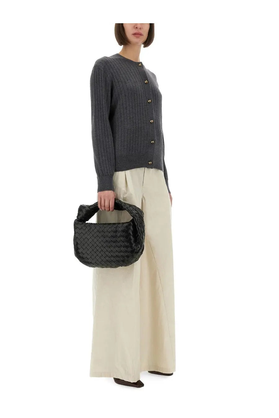 Black woven leather bottega veneta handbag with structured rounded shape and top handle shown with grey wool cardigan