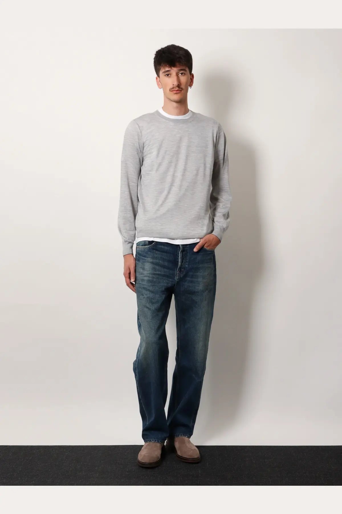 A man wearing a brunello cucinelli men’s grey cashmere and silk long-sleeved crewneck sweater with white collar
