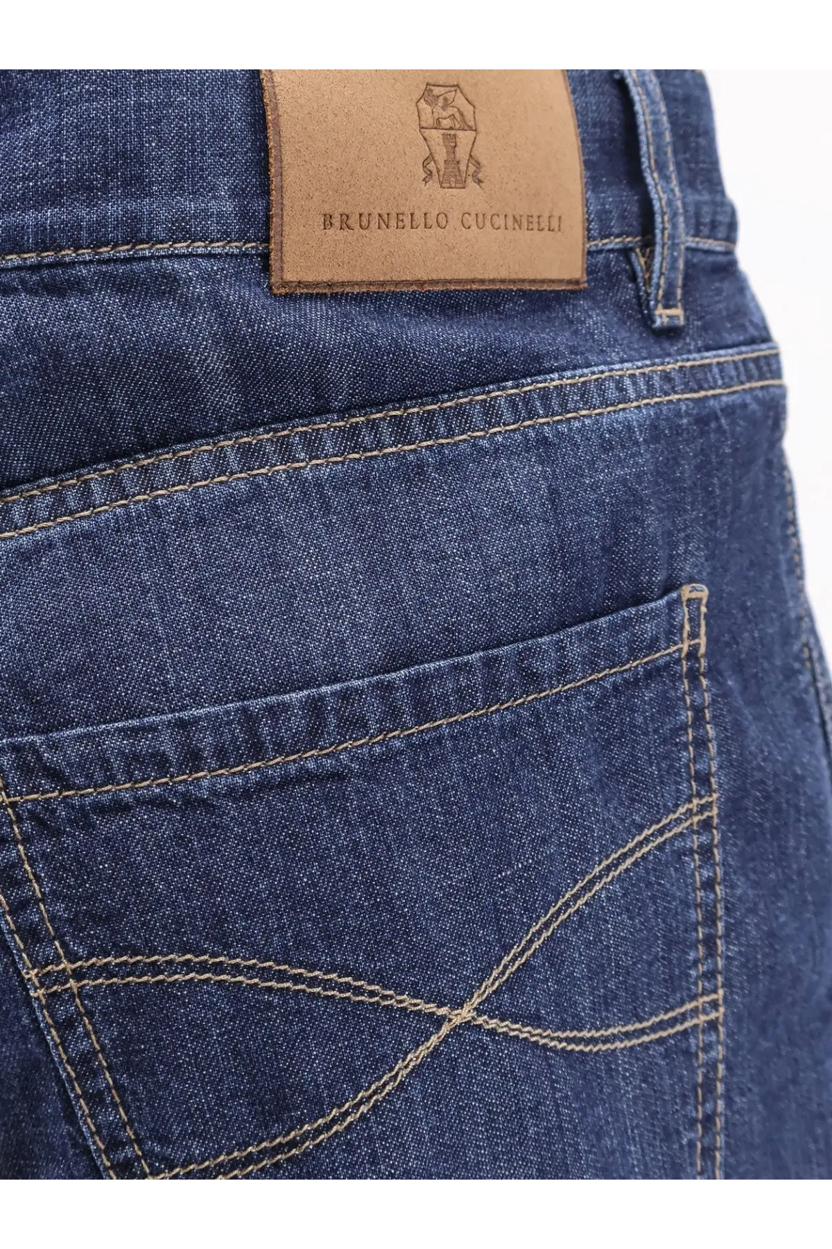 Dark blue cotton denim jeans with tan leather brunello cucinelli brand patch on the back waistband