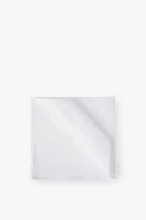 A crisp white silk pocket square by Brunello Cucinelli with subtle sheen and clean edges neatly folded